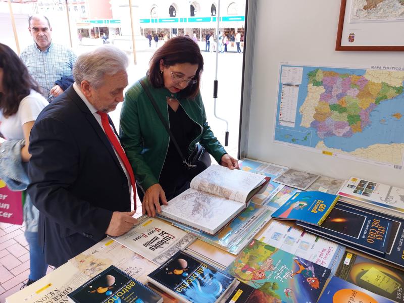 Alicia Villar visita la caseta del Instituto Geográfico Nacional en la Feria del Libro, que ofrece como novedad mapas a la carta